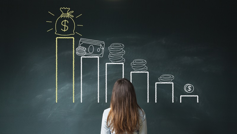 Business woman standing in front of a blackboard with a financial chart