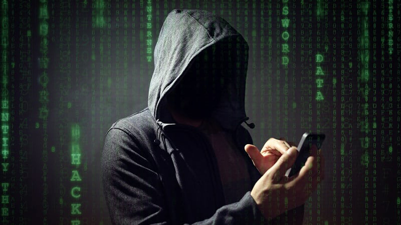 Hooded man uses a mobile phone with words hacker and data in the background