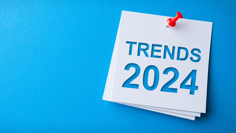 Trends 2024 Word in White Sticky Note on Yellow Cardboard Background