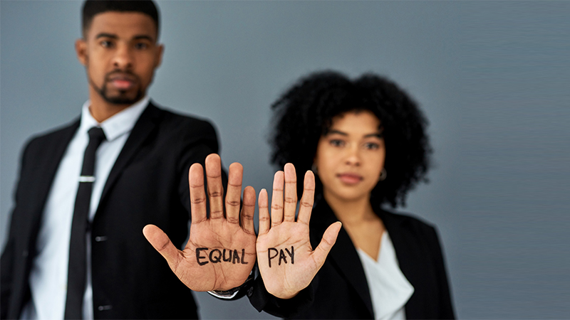 Shot of a businessman and businesswoman advocating for equal pay against a grey studio background