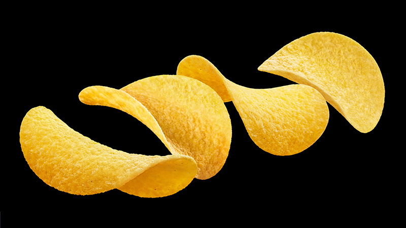 Delicious potato chips, isolated on black background