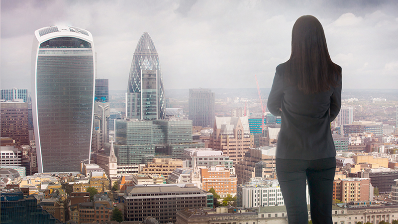 Young woman looking over the City of London at sun set. Future, new business opportunity and business success concept.