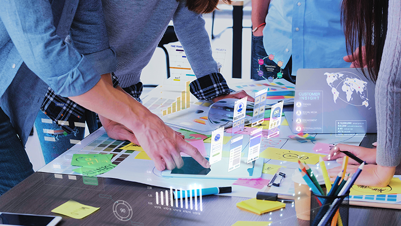 Close up ux developer and ui designer use augmented reality app brainstorming about mobile interface wireframe design on desk at modern office.Creative digital development agency