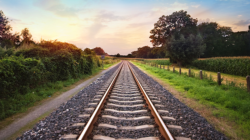 railway tracks in a rural scene with nice pastel sunset, tracker funds