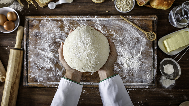 Artisanal bakery: Artisan Chef Hands kneading dough. Artisanal bakery is bread made by a craftsperson using mainly traditional techniques. Also, it is usually made by hand, however, many artisanal bakeries use also electrical mixers and dividers. The bakers who do everything by hand tend to draw a line differently than the bakers who use lots of automated equipment. Artisanal bakery, only made by hand, is part of the romantic and traditional way of cooking from old times.