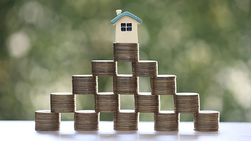 Mortgage,Model house and stack of coins money on natural green background,Business investment and real estate concept