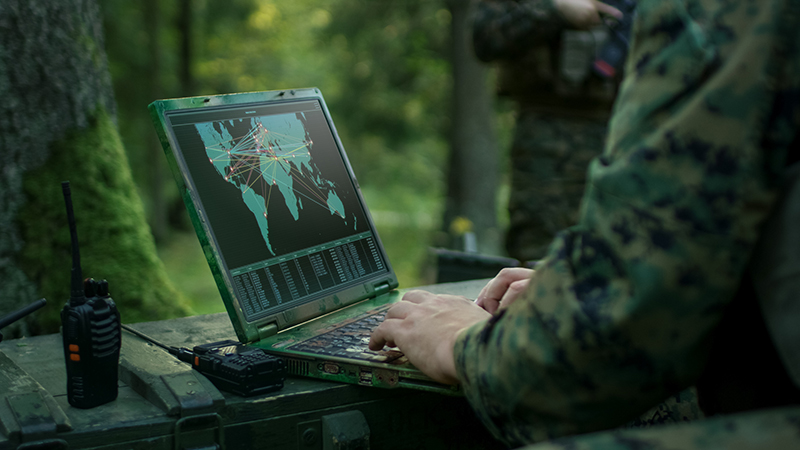 Military Operation in Action, Soldiers Using Military Grade Laptop Targeting Enemy with Satellite. In the Background Camouflaged Tent on the Forest.