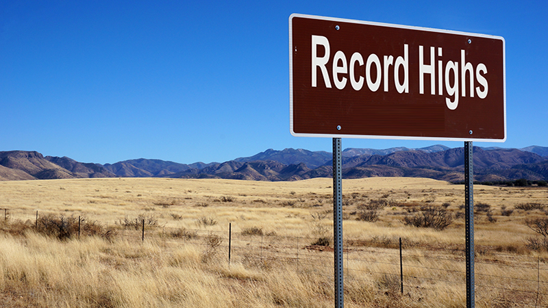 Record Highs road sign with blue sky and wilderness