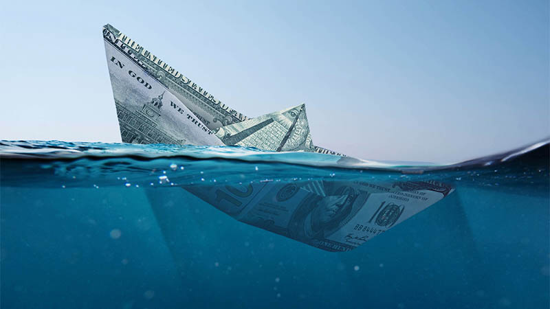 Concept paper dollar boat sinking in the sea with a view underwater. Finance and crisis, a creative idea. Falling exchange rates. Insurance
